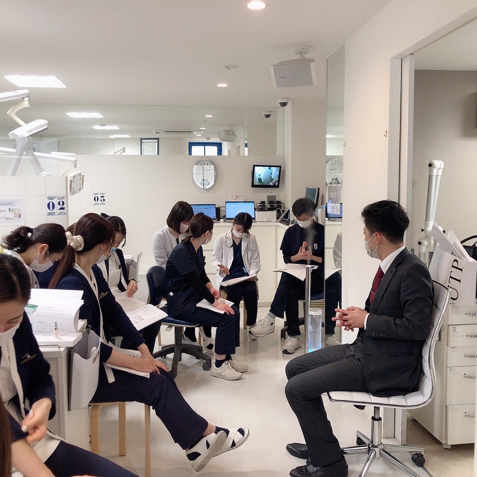 院内で輪になって話し合うスタッフ